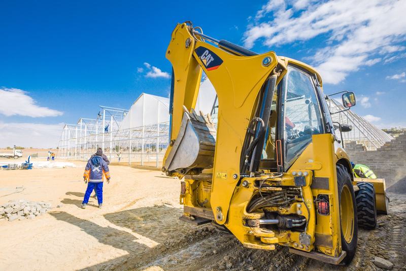 A construction crew and a yellow excavator working on a site in South Africa