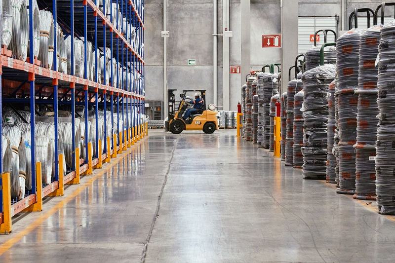 Forklift moving pallets down the aisle of a distribution warehouse